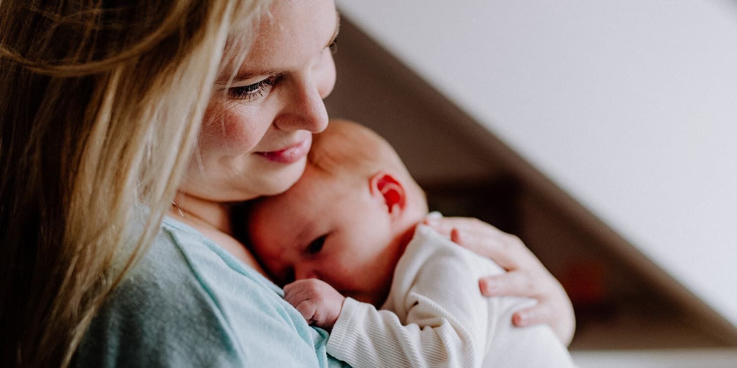 Eine Mutter, die ihr Baby beruhigt und es in den Armen hält.