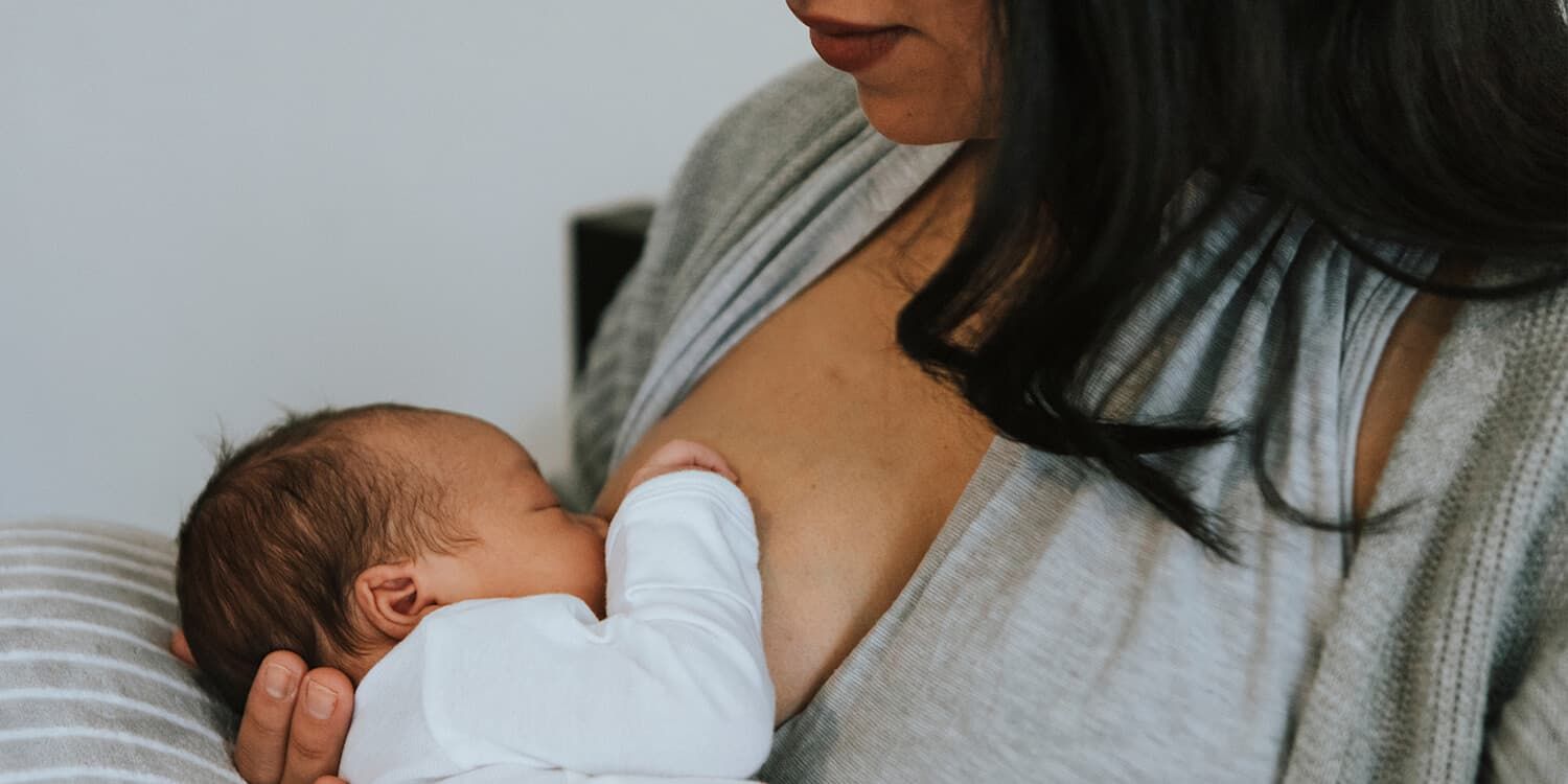 newborn baby drinking from mothers breast