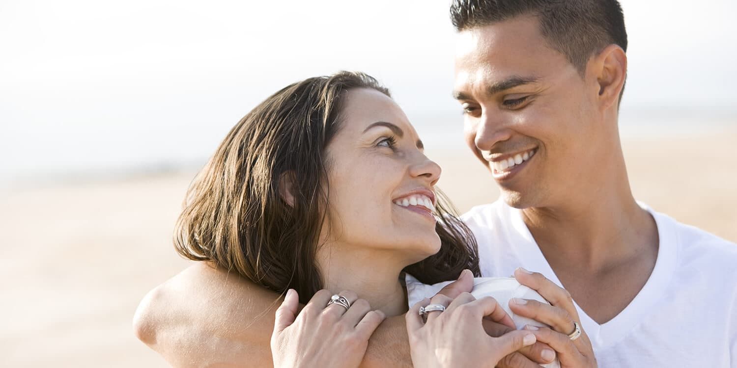 Una pareja feliz se abraza al aire libre.