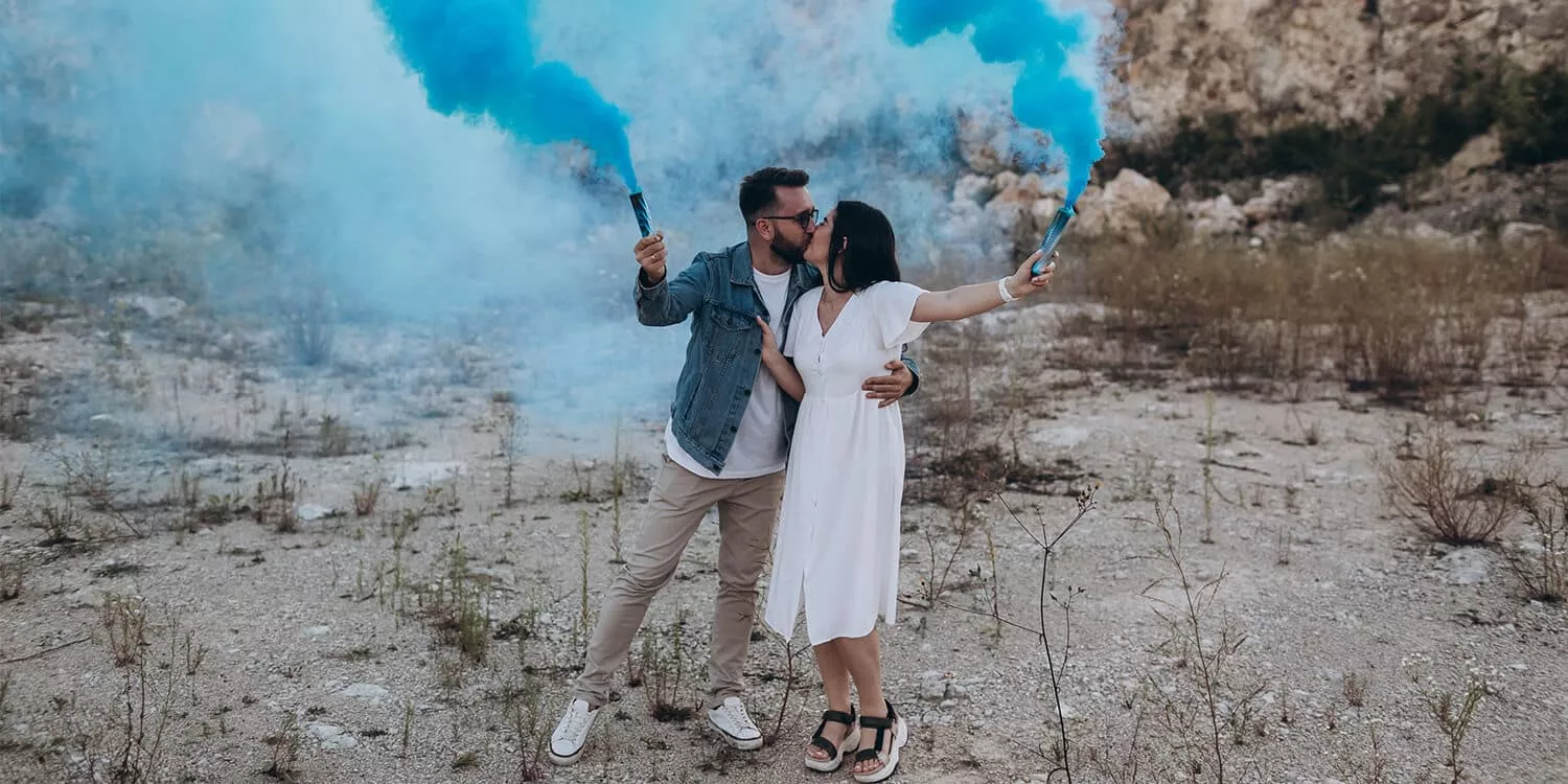 Future parents hold up blue party flares to indicate that their child will be a boy. 