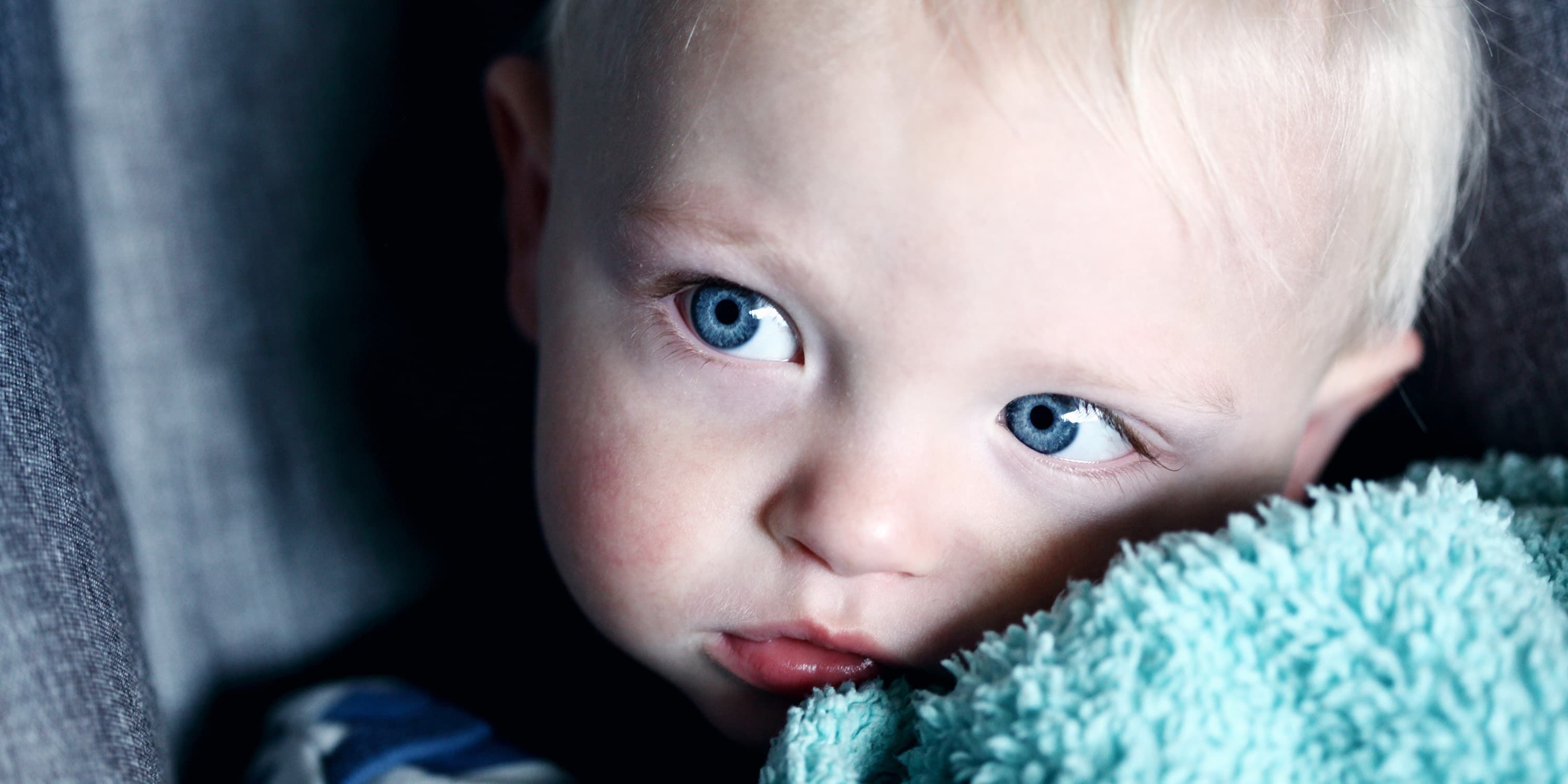 Baby holds towel to her cheek