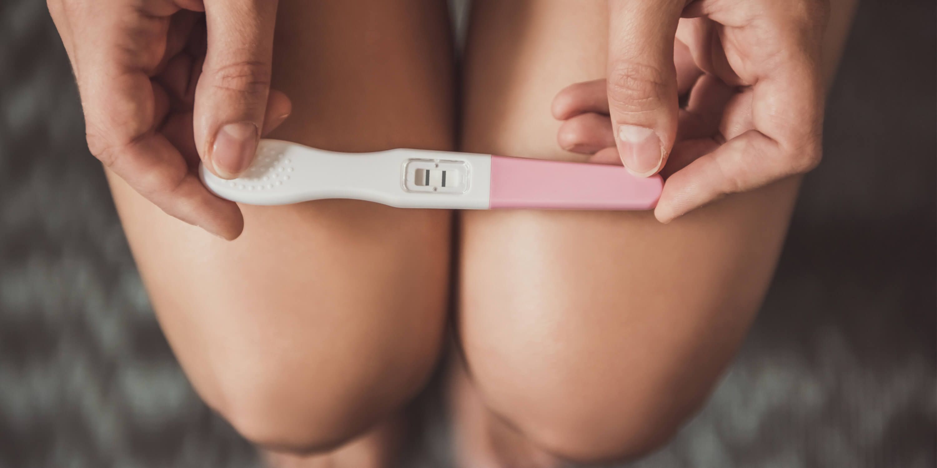 Young woman holds a pregnancy test in her hands. 