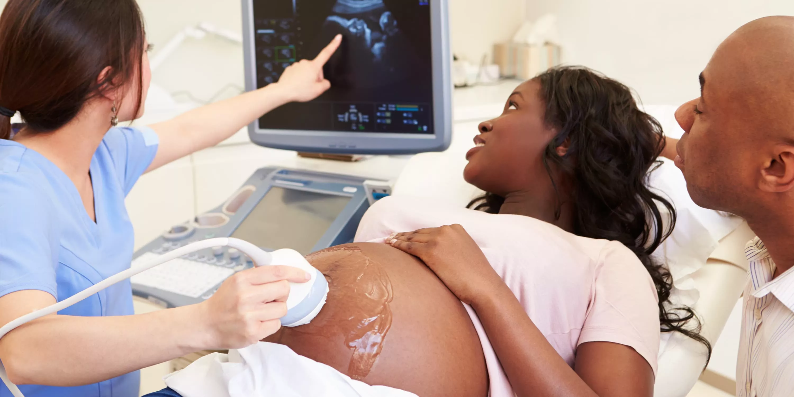 Schwangere Frau mit Partner bei Ultraschalluntersuchung (35. SSW)