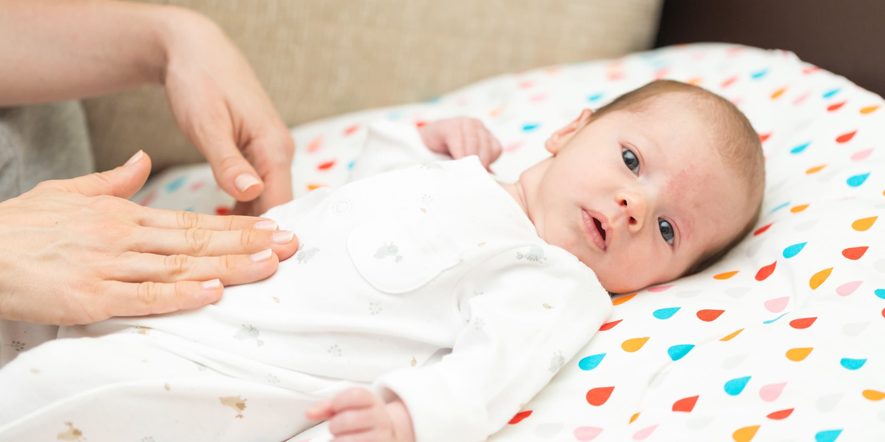 Mother gently massaging baby belly